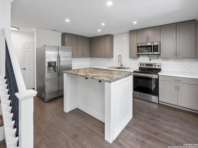 kitchen featuring sink, dark hardwood / wood-style floors, stainless steel appliances, and a center island