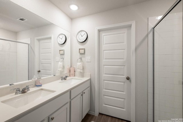 bathroom featuring tiled shower, vanity, and hardwood / wood-style floors