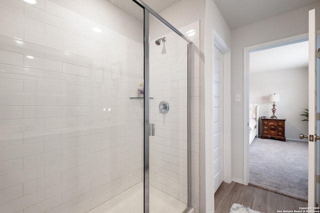 bathroom featuring hardwood / wood-style floors and a shower with shower door