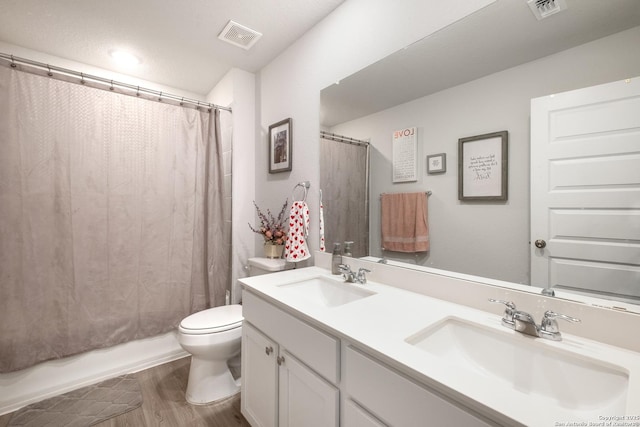 full bathroom featuring vanity, toilet, wood-type flooring, and shower / bath combo