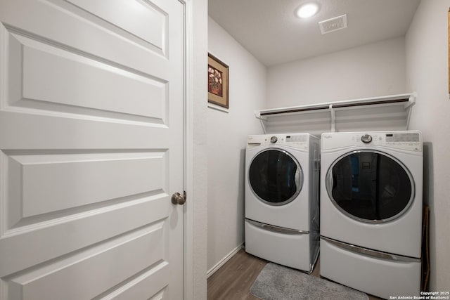 laundry room with dark hardwood / wood-style floors and washing machine and dryer