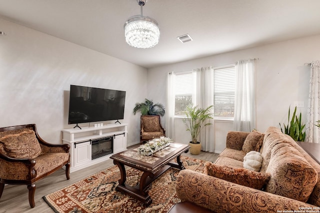 living room featuring an inviting chandelier and light wood-type flooring