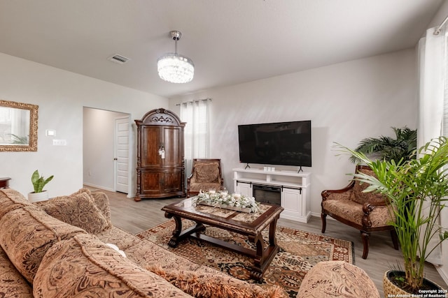 living room with a chandelier and light hardwood / wood-style floors