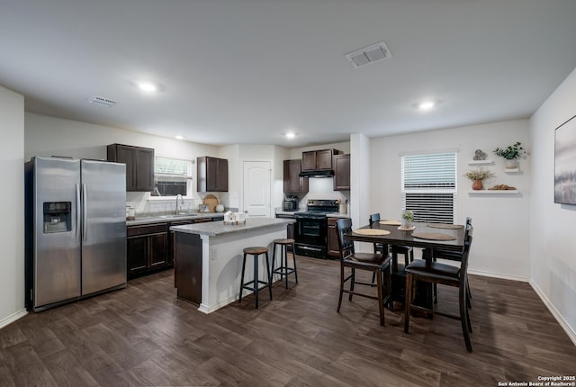 kitchen featuring a breakfast bar, a center island, stainless steel fridge with ice dispenser, black / electric stove, and dark hardwood / wood-style floors