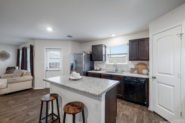 kitchen featuring stainless steel refrigerator with ice dispenser, a breakfast bar, sink, dishwasher, and a kitchen island