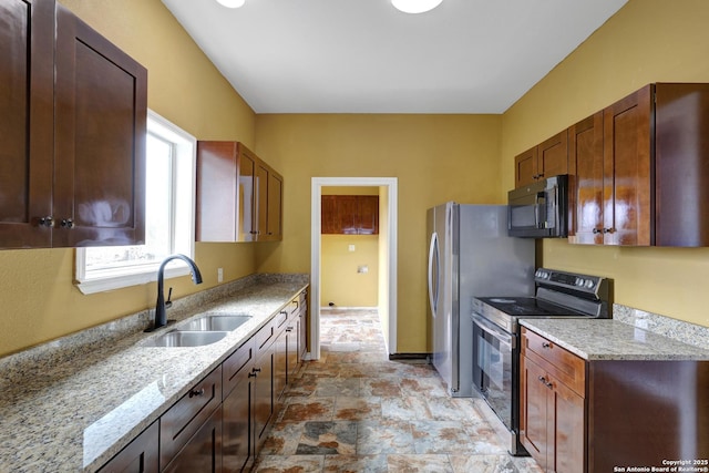 kitchen featuring light stone counters, sink, and stainless steel electric range