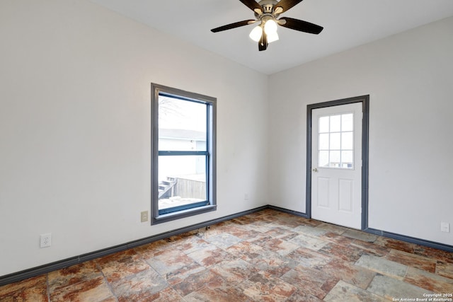 empty room featuring a wealth of natural light and ceiling fan