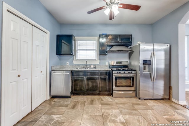 kitchen featuring light stone countertops, appliances with stainless steel finishes, sink, and ceiling fan