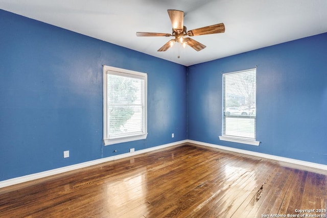 spare room featuring ceiling fan, a healthy amount of sunlight, and wood-type flooring