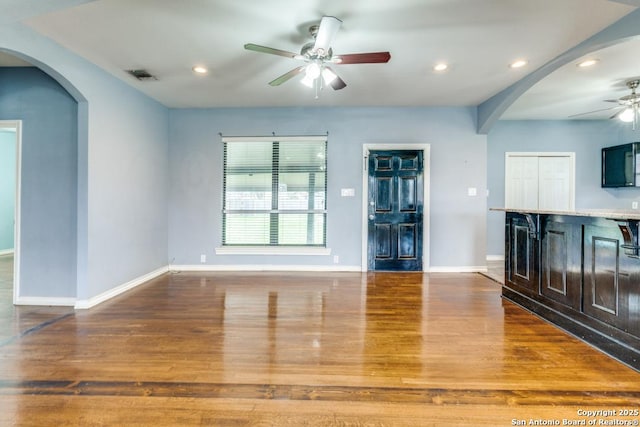 unfurnished living room featuring hardwood / wood-style flooring and ceiling fan