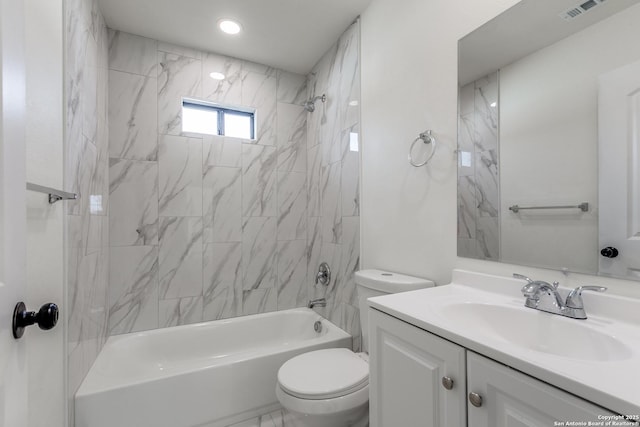 full bathroom featuring tiled shower / bath, vanity, and toilet