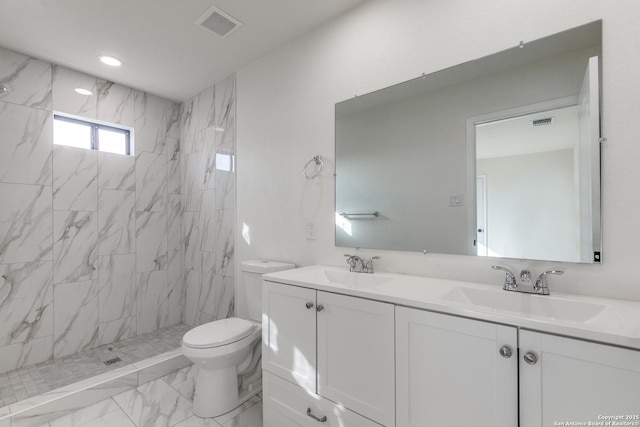 bathroom featuring vanity, tiled shower, and toilet