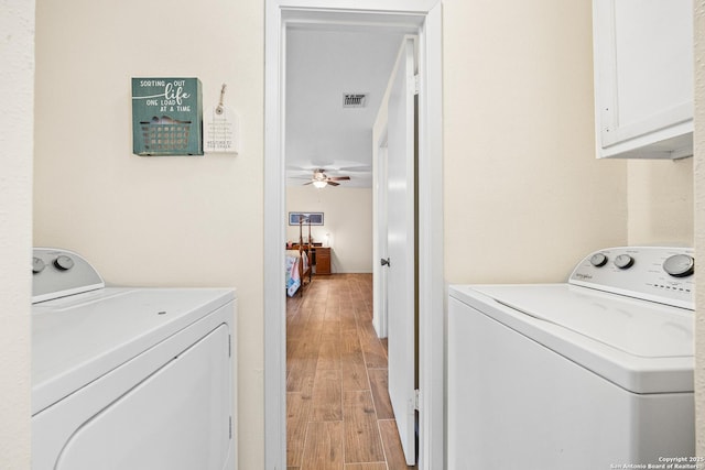 clothes washing area featuring cabinets, independent washer and dryer, ceiling fan, and light hardwood / wood-style floors