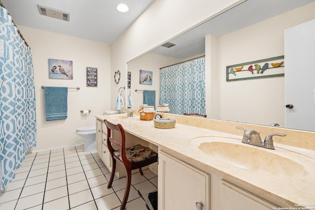 bathroom featuring vanity, toilet, and tile patterned flooring