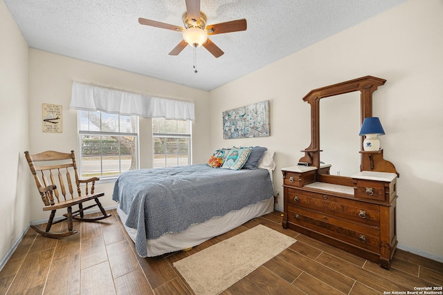 bedroom with ceiling fan, dark hardwood / wood-style floors, and a textured ceiling