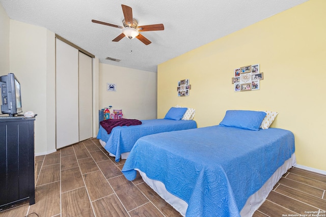 bedroom with ceiling fan, a closet, and a textured ceiling