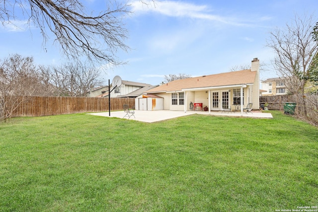 back of property with a storage shed, a lawn, and a patio