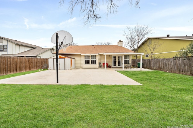 rear view of house with french doors, a yard, a shed, and a patio area