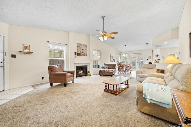 living room featuring ceiling fan with notable chandelier, high vaulted ceiling, a fireplace, light carpet, and a textured ceiling