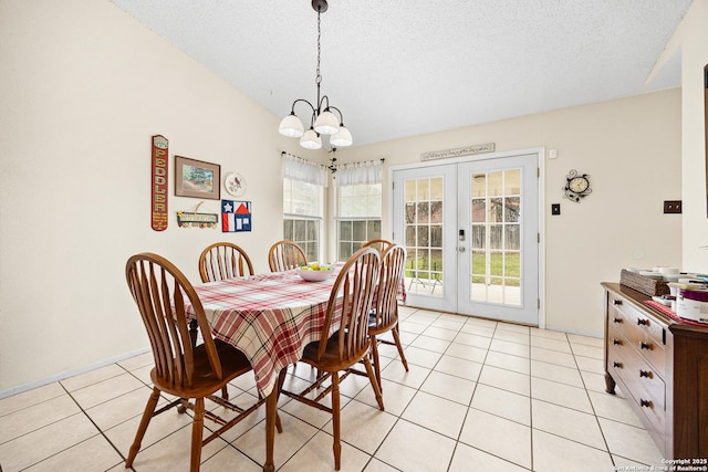 tiled dining room with a notable chandelier, french doors, and a textured ceiling