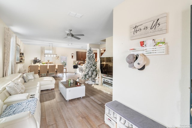 living room featuring ceiling fan and light hardwood / wood-style floors