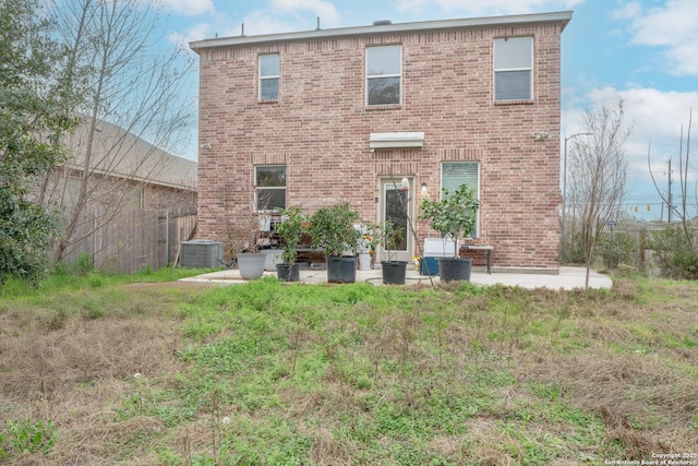 rear view of property with a patio, a lawn, and central air condition unit