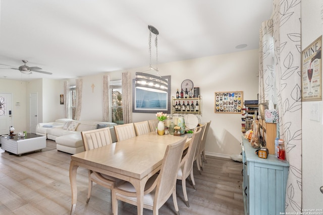 dining space featuring wood-type flooring and ceiling fan