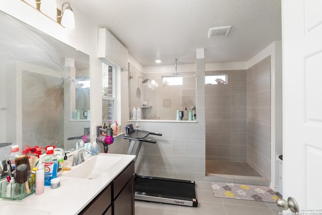 bathroom featuring vanity, tile patterned floors, and tiled shower