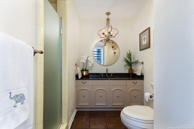 bathroom with vanity, an enclosed shower, toilet, tile patterned floors, and an inviting chandelier