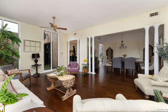 living room with ornate columns, dark wood-type flooring, and ceiling fan with notable chandelier