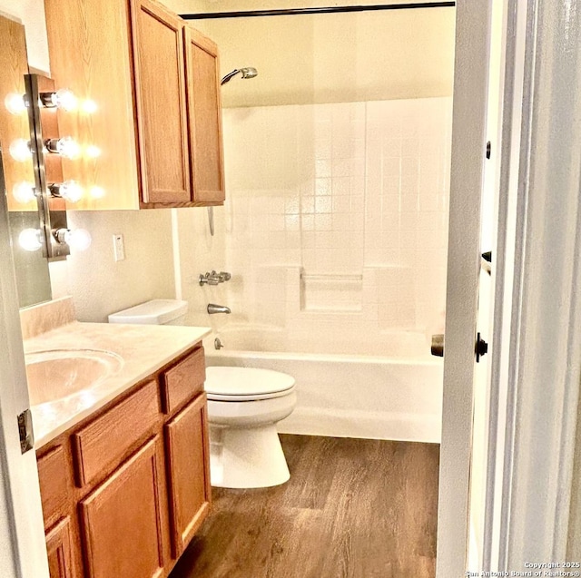 full bathroom featuring vanity, hardwood / wood-style flooring, shower / washtub combination, and toilet