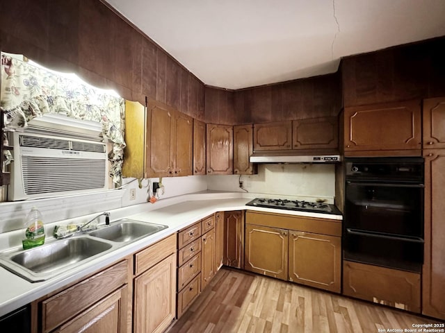 kitchen featuring sink, light hardwood / wood-style flooring, cooling unit, stainless steel gas stovetop, and oven