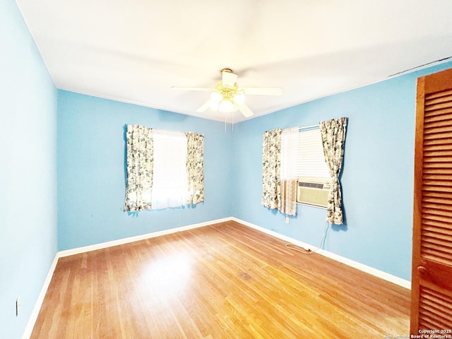 unfurnished room with cooling unit, ceiling fan, and wood-type flooring