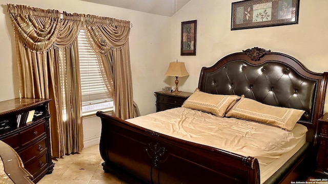 bedroom featuring vaulted ceiling and light tile patterned flooring