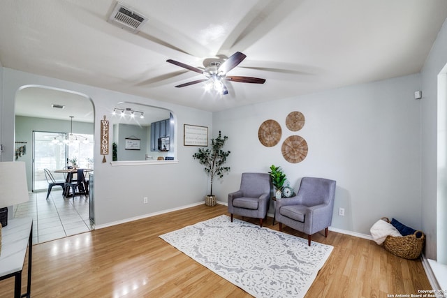 sitting room featuring wood-type flooring and ceiling fan