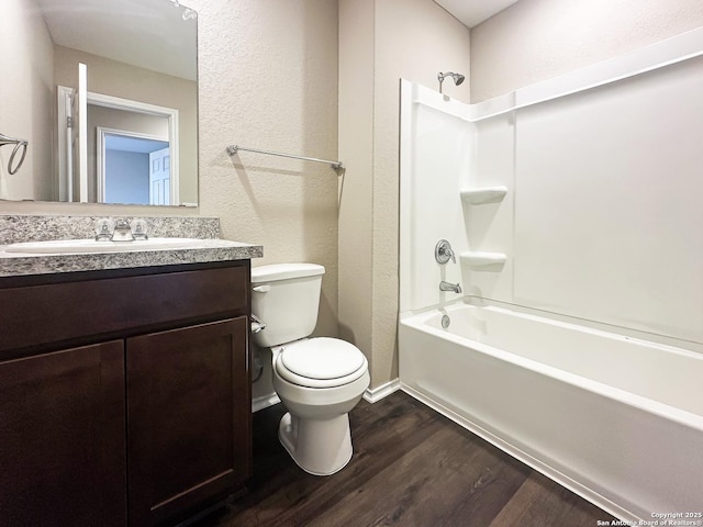 full bathroom with hardwood / wood-style flooring, shower / bathtub combination, vanity, and toilet