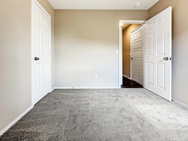 unfurnished bedroom featuring dark carpet