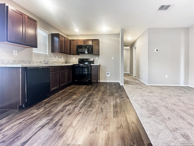 kitchen featuring dark brown cabinetry, dark hardwood / wood-style floors, and black appliances