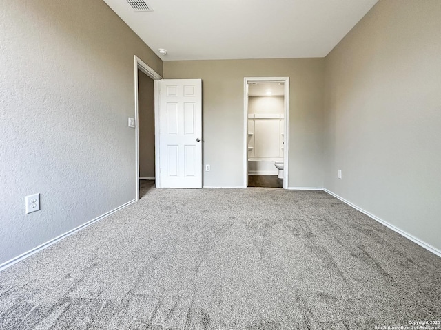 unfurnished bedroom with carpet flooring and connected bathroom