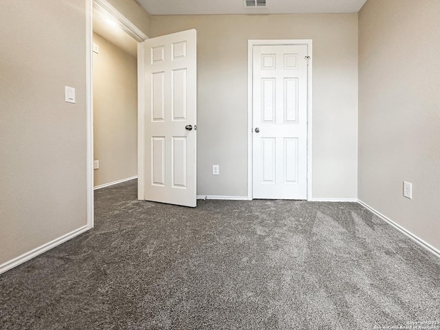 unfurnished bedroom with dark colored carpet