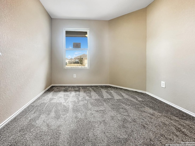 spare room with dark colored carpet