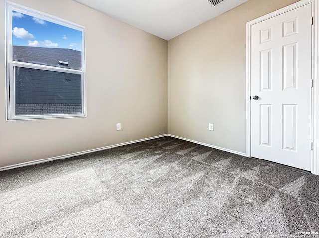 empty room with dark colored carpet