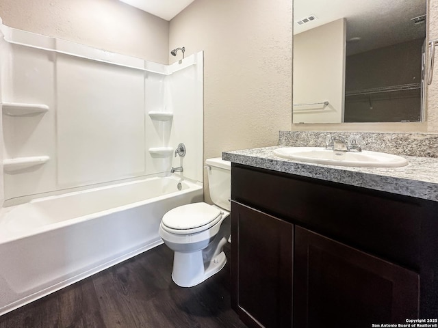 full bathroom with vanity, hardwood / wood-style floors,  shower combination, and toilet