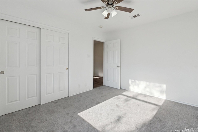 unfurnished bedroom featuring light carpet, ceiling fan, and a closet