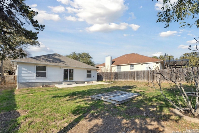 back of house with a patio area and a lawn