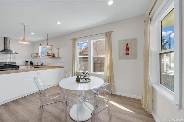 dining area with sink and light hardwood / wood-style flooring