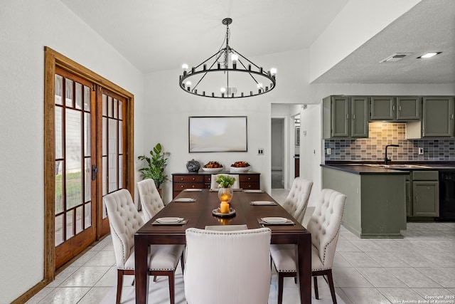 dining room featuring an inviting chandelier, sink, french doors, and light tile patterned floors