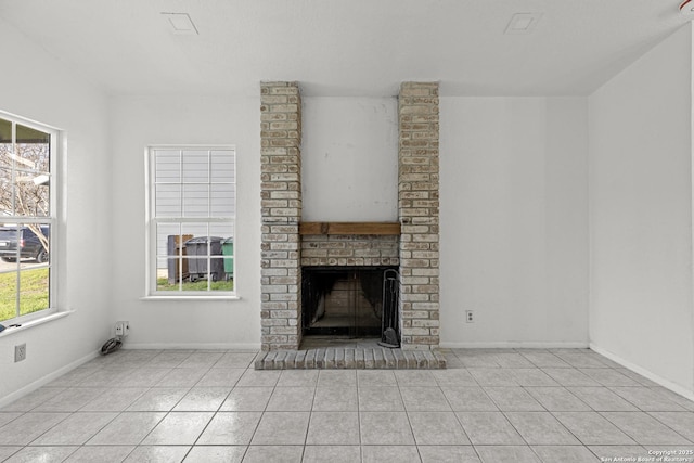 unfurnished living room featuring a brick fireplace and light tile patterned floors