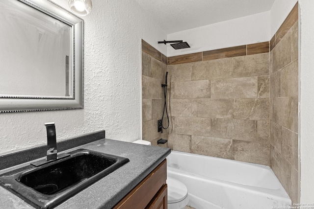 full bathroom featuring tiled shower / bath combo, vanity, a textured ceiling, and toilet