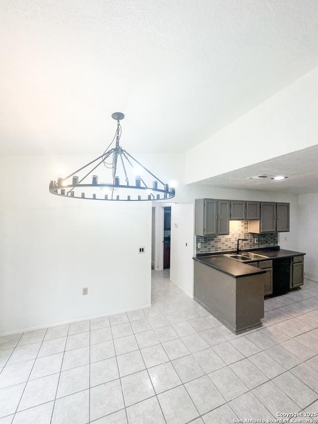 kitchen featuring pendant lighting, sink, lofted ceiling, tasteful backsplash, and light tile patterned flooring